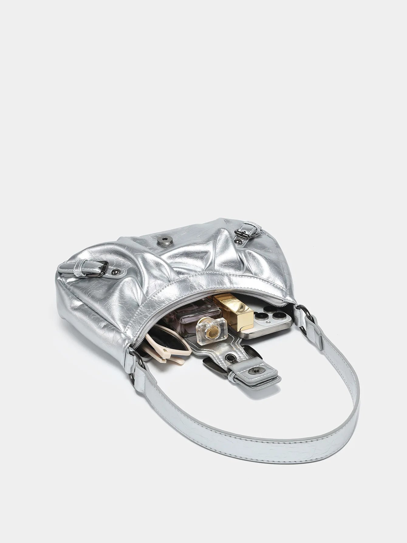 Silver Y2K style leather shoulder bag with exposed contents, showcasing vintage design and modern appeal.