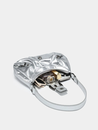 Silver Y2K style leather shoulder bag with exposed contents, showcasing vintage design and modern appeal.