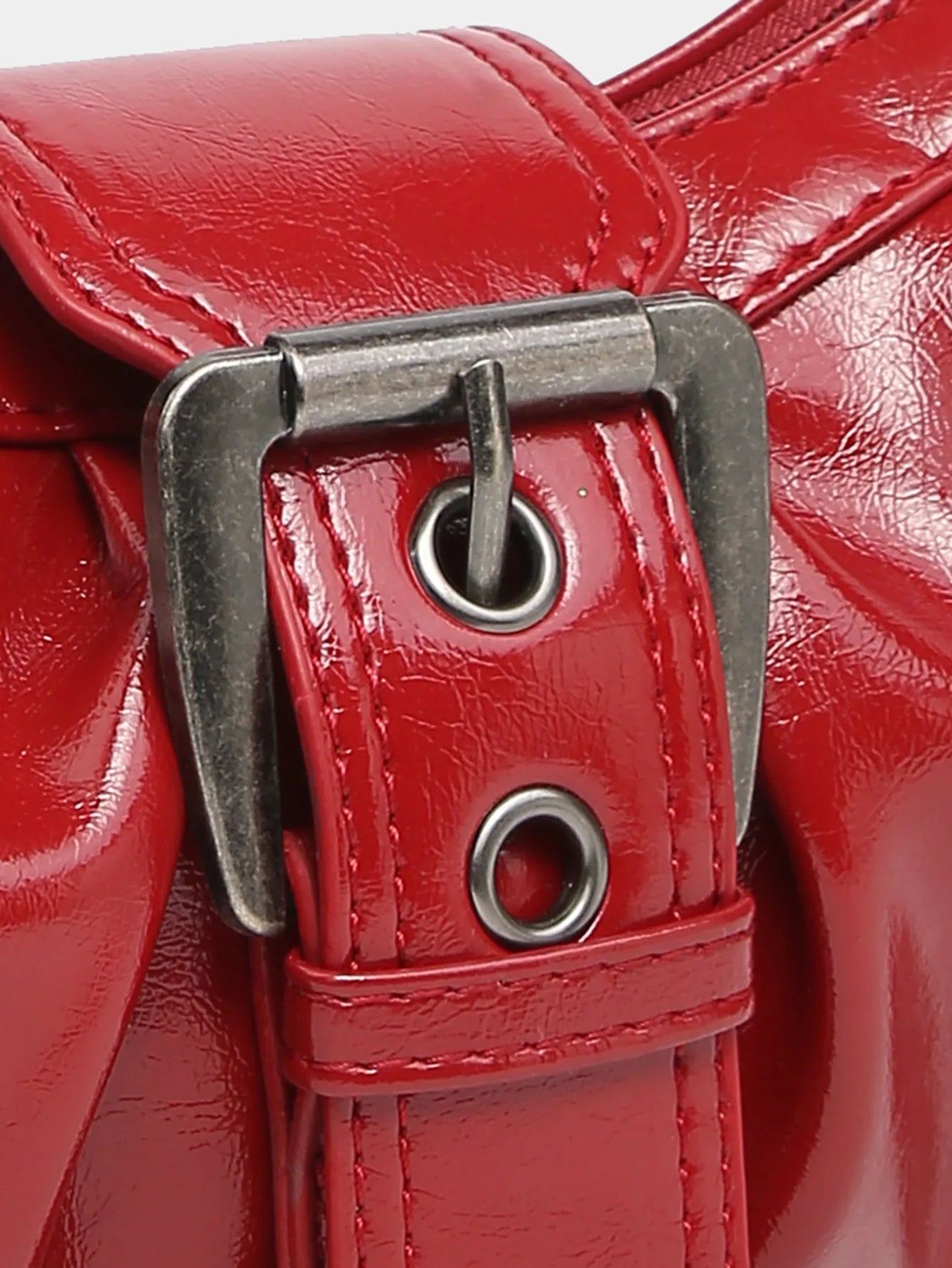 Close-up of a red leather shoulder bag buckle, showcasing Y2K vintage accessory style and smooth finish.